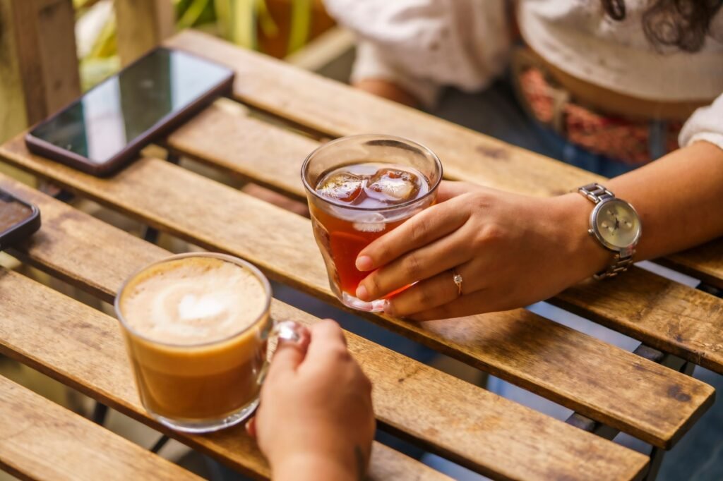 Hands holding a smartphone beside a cup of tea, illustrating a respectful online conversation