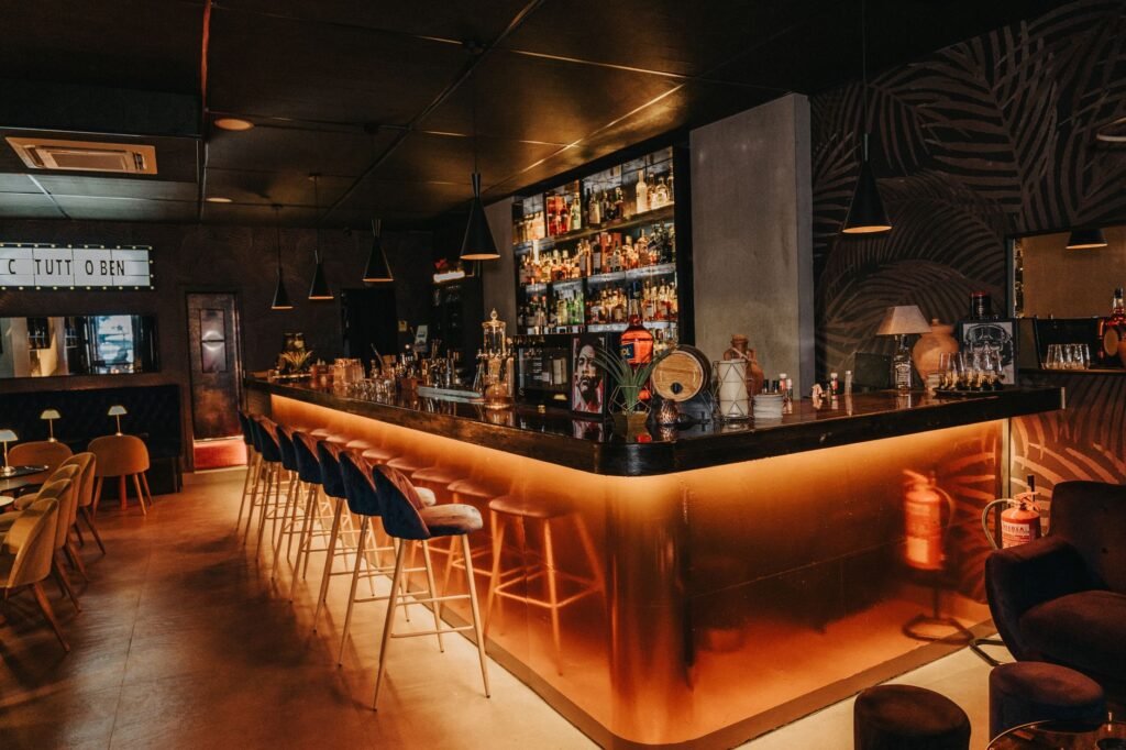 Stylish bar interior featuring an illuminated counter and modern decor, perfect for nightlife.