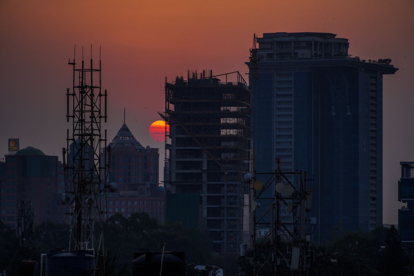 Captivating city skyline at sunset in Bengaluru with buildings silhouetted against a vibrant sky.
