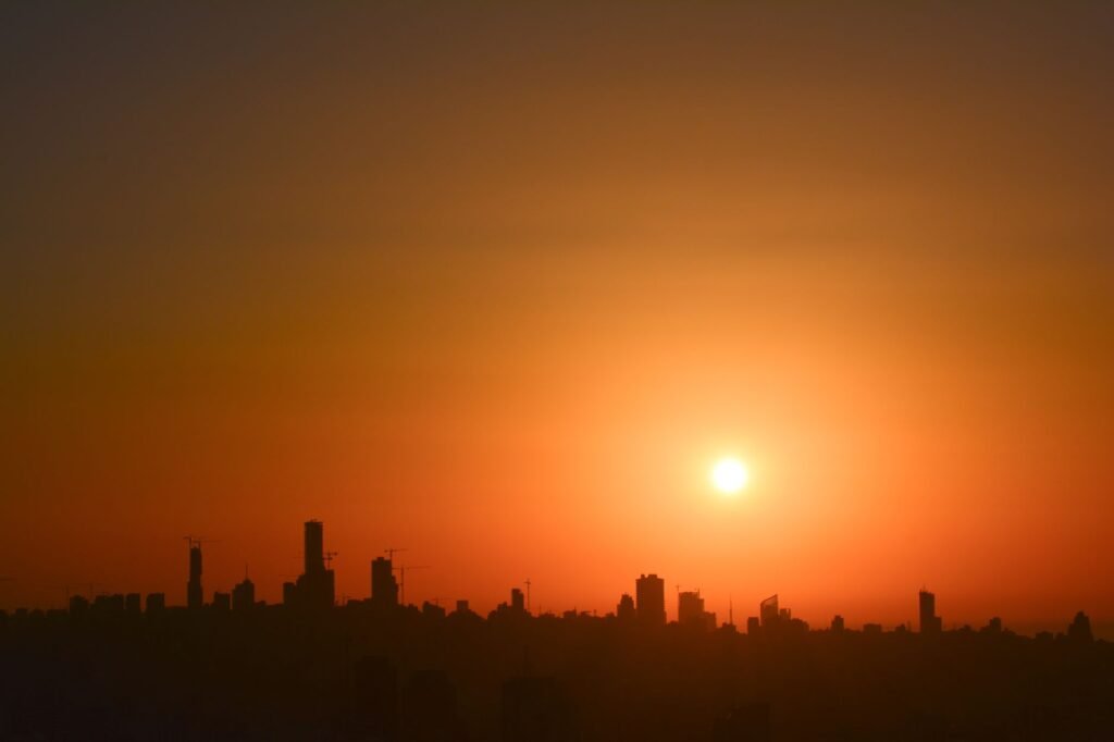 A breathtaking view of a city skyline silhouetted against a vivid sunset, capturing serene urban beauty.