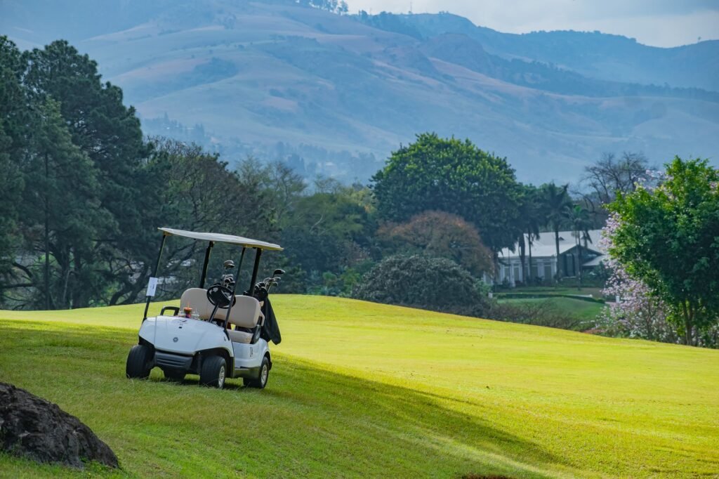 A picturesque view of a golf course with a golf cart in Piggs Peak, Eswatini.