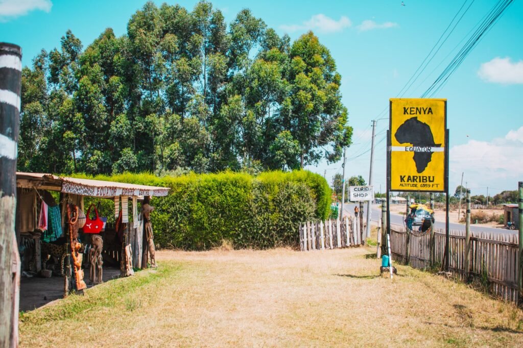 Simple roadside eatery in rural Kenya with people seated outside in the early evening