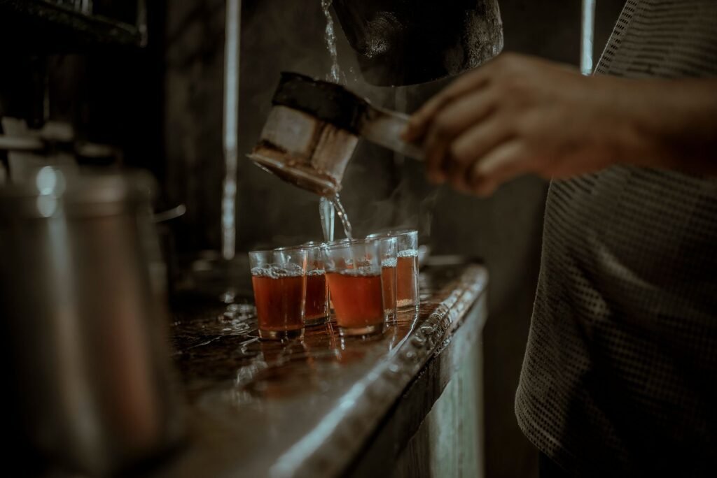 Glasses of spiced tea on a small table at a simple roadside tea point in the early evening