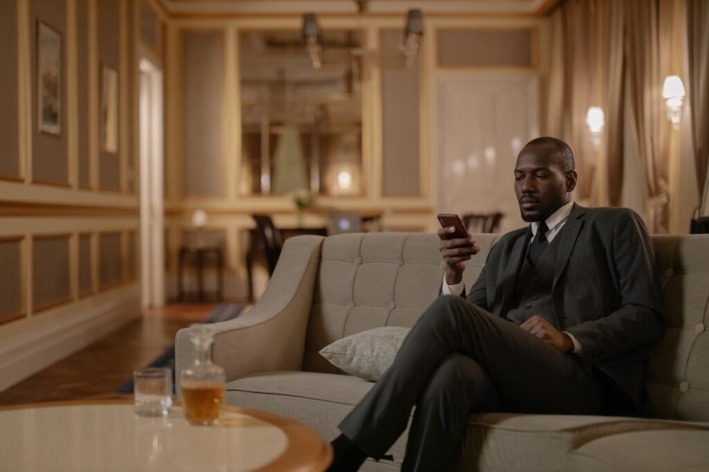 Traveller checking a smartphone in a softly lit hotel room in the evening