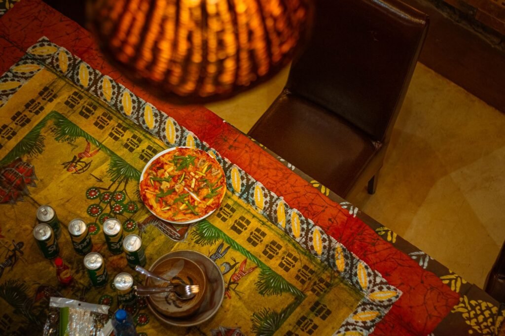 Table with local dishes and a drink in a softly lit Kenyan restaurant at dusk