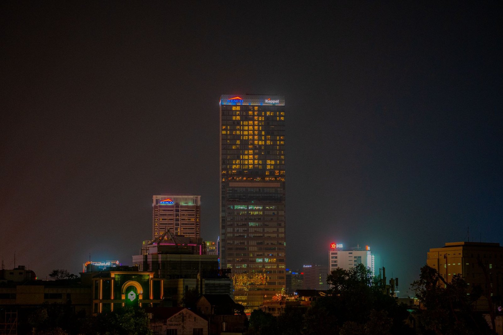 Illuminated skyscrapers in the night skyline of Ho Chi Minh City, showcasing urban architecture.
