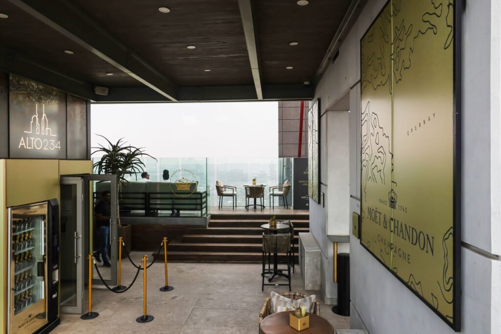 Stylish rooftop bar with city view, featuring Moët & Chandon decor and modern seating.