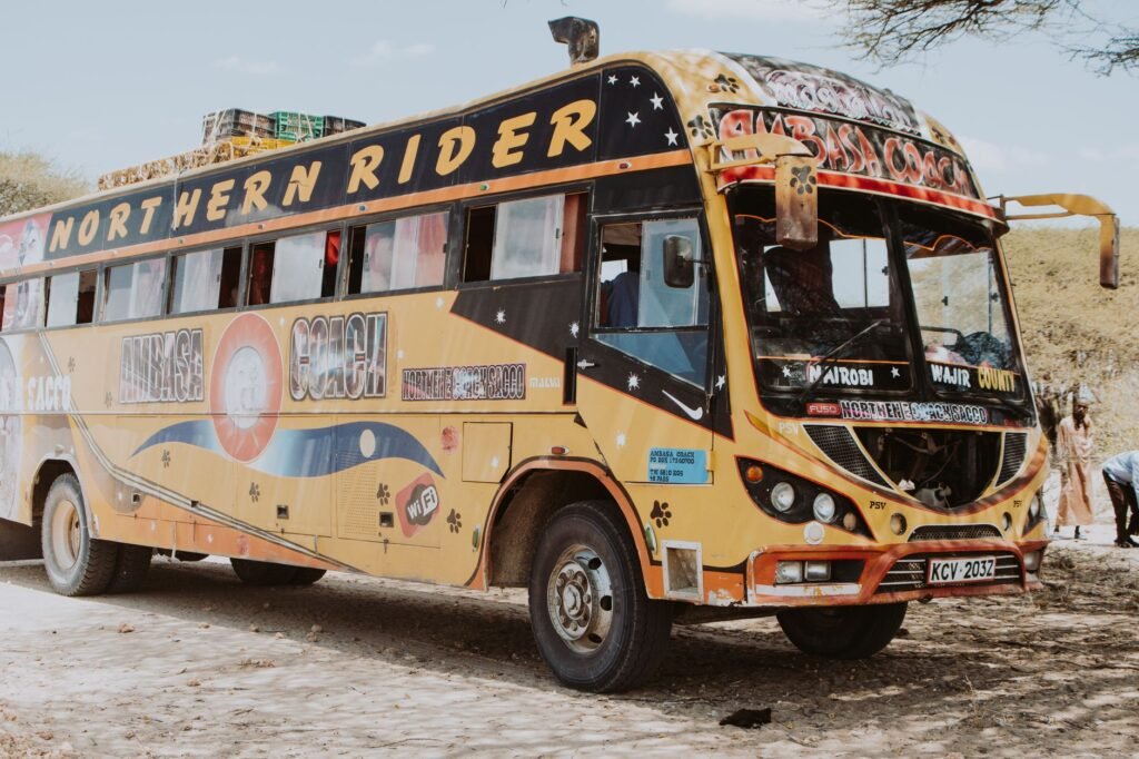 A vibrant Northern Rider bus parked on a dusty road in rural Kenya, showcasing local travel culture.