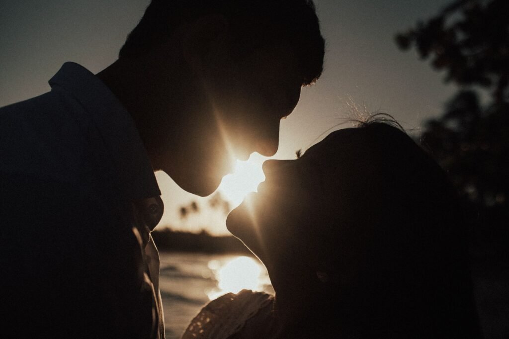 A romantic silhouette of a couple kissing during sunset, capturing the beauty of love and nature.