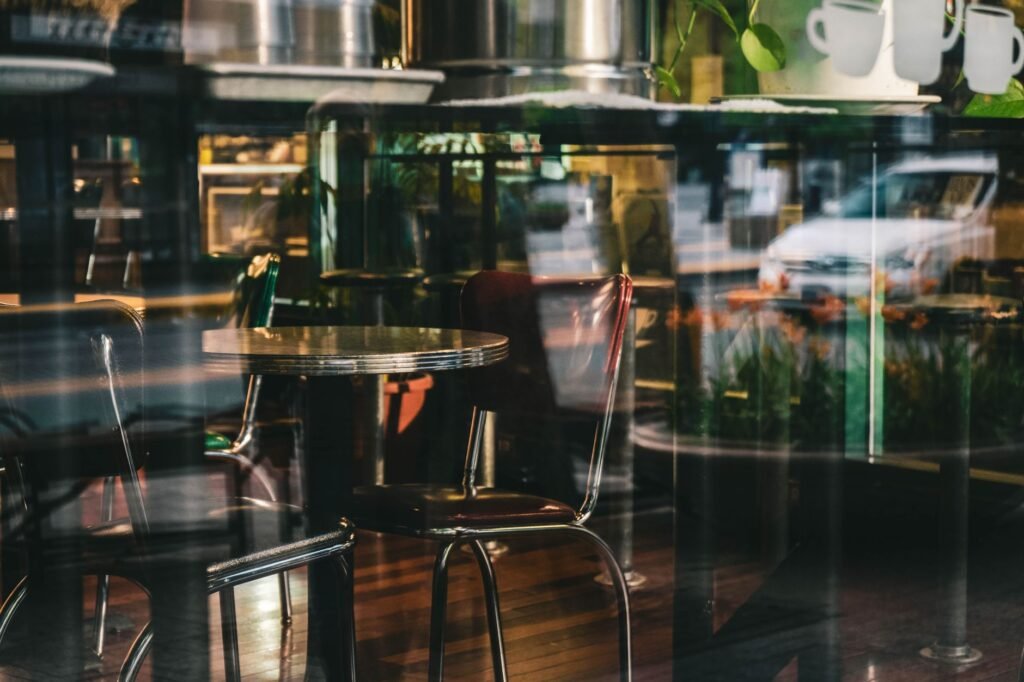 Elegant interior of a modern café with glass reflections and sleek furnishings, creating a serene ambiance.