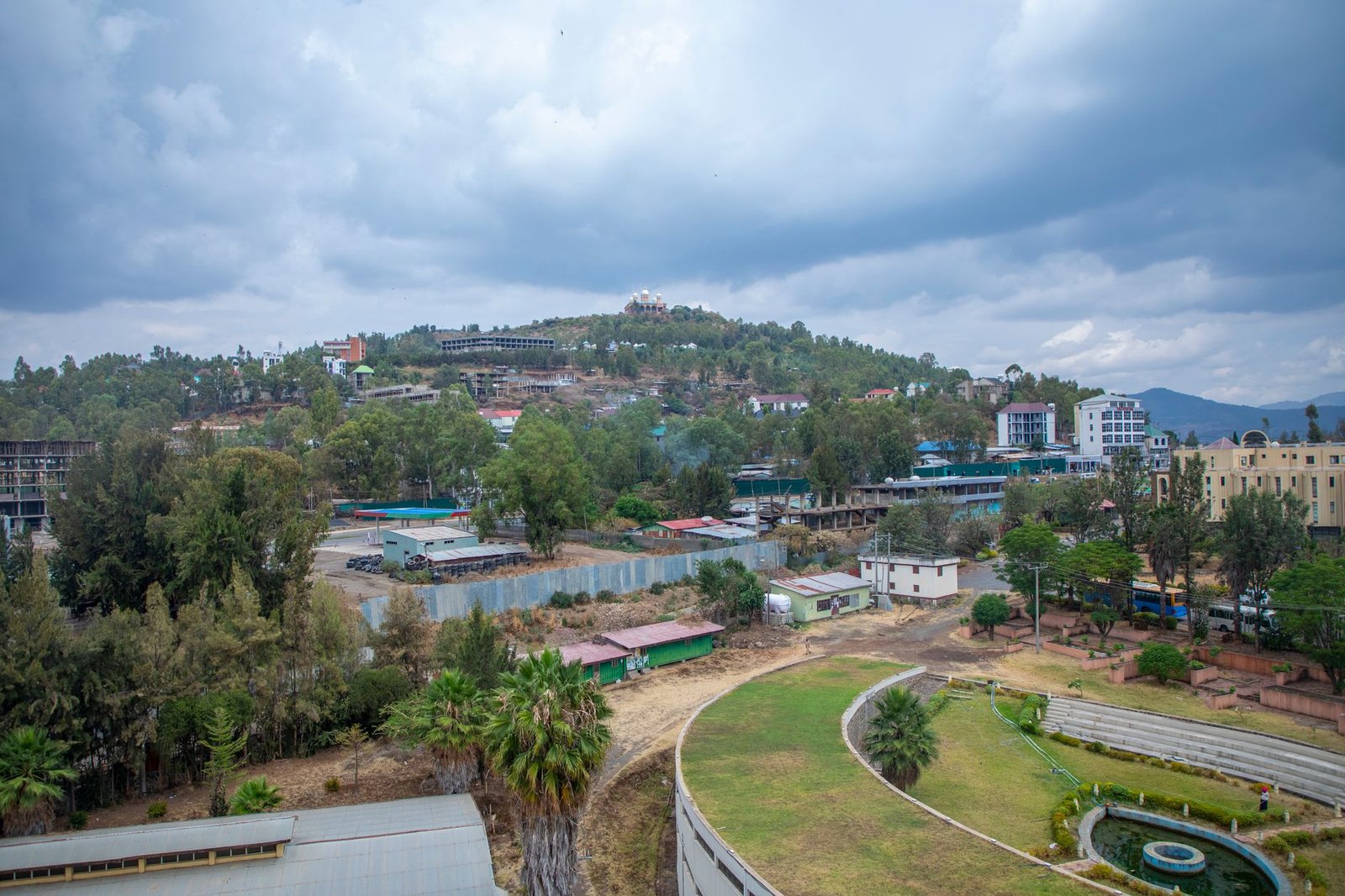 Captivating aerial view of Gondar, Ethiopia with lush greenery and architecture under a cloudy sky.