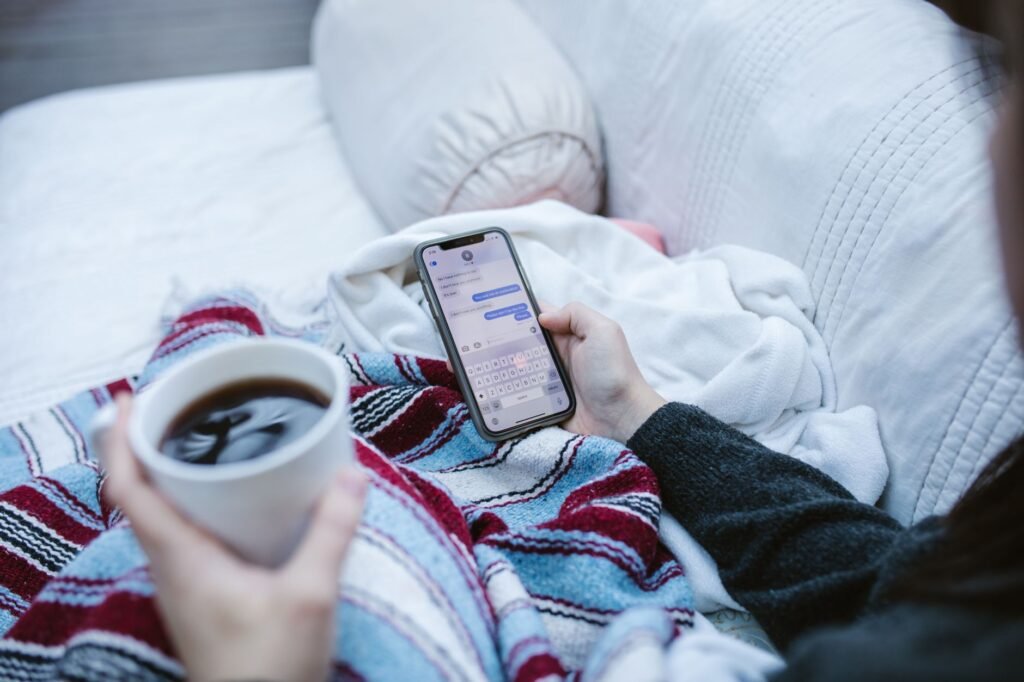 Smartphone and cup of tea on a table, representing a first polite booking message