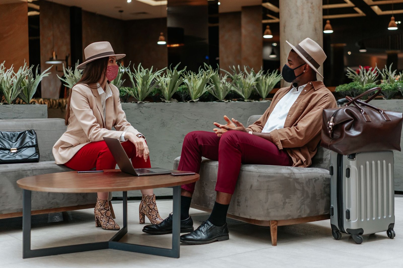Two adults having a calm conversation at a hotel lobby table in a Kenyan town