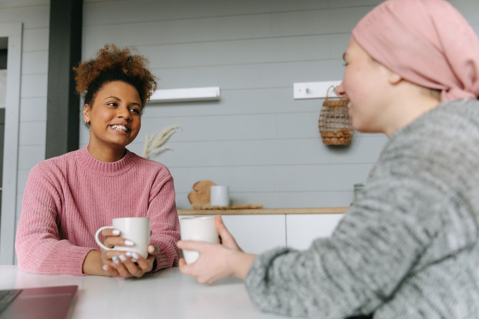 Two adults in calm conversation at a small table in a warmly lit room