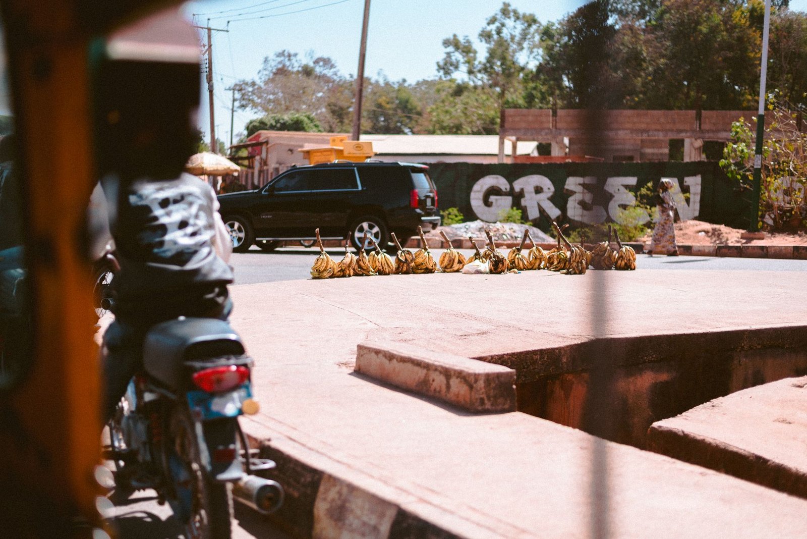 Street view of daily life with motorbikes and vendors in Jos Plateau, Nigeria.