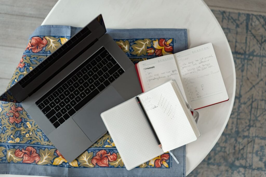 Notebook and laptop on a desk in a guesthouse room used for planning