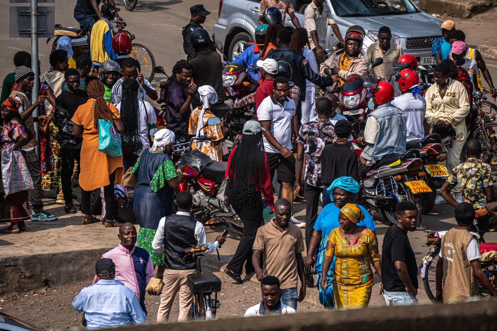 A bustling street scene filled with people and motorcycles, capturing urban life.