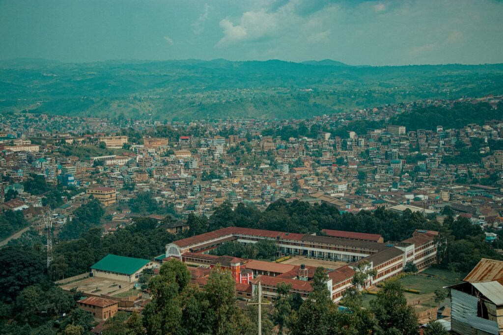 Aerial shot of Bukavu cityscape against lush hills, showcasing urban architecture and natural landscape.