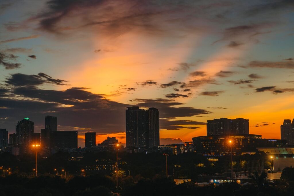 Vibrant city skyline at sunset with dramatic clouds and lighting.