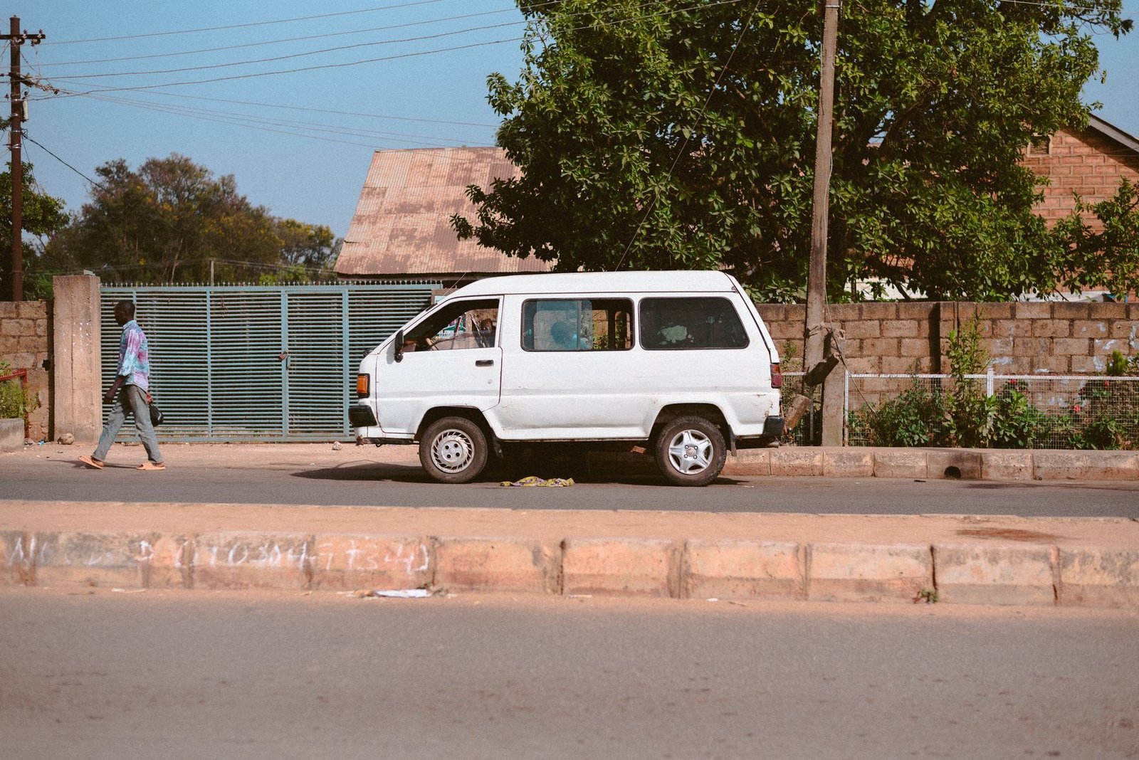 Outdoor street view of a white van in Jos Plateau, showcasing local transit life.
