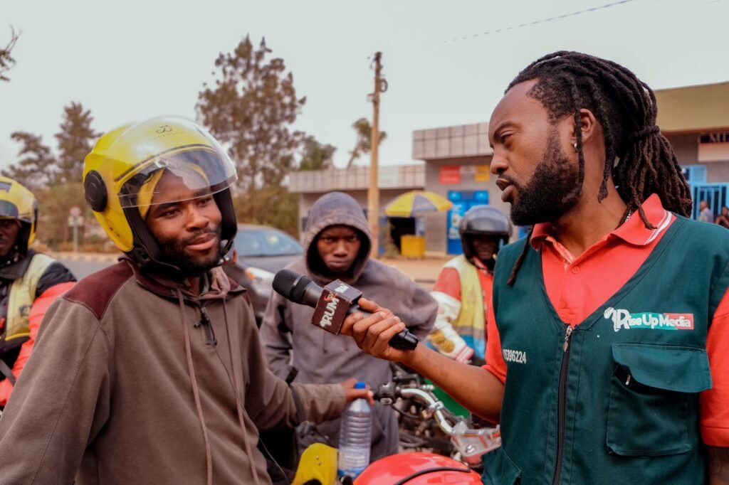 Journalist interviews motorcycle riders outdoors for a news segment.