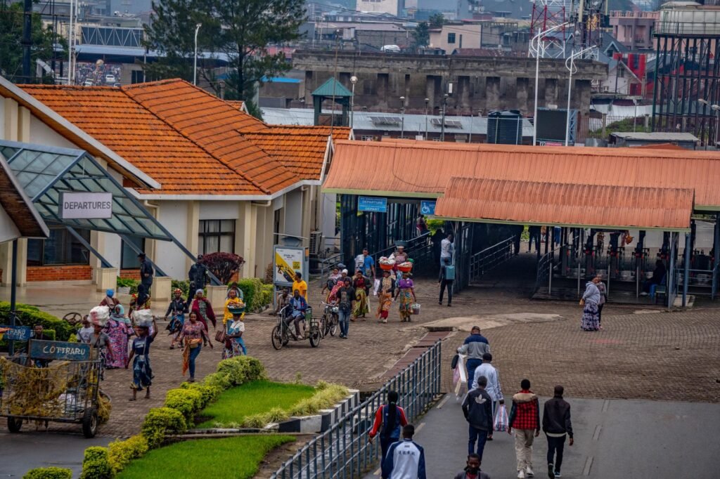 Busy transport terminal with people walking and orange rooftops, showcasing daily city life.