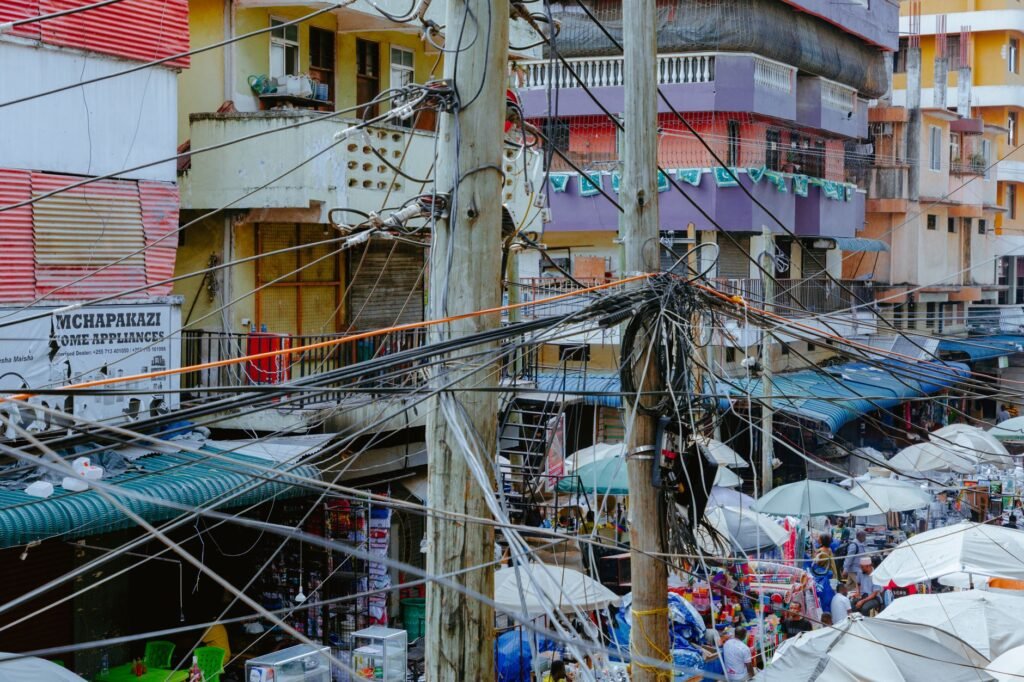 Vibrant market scene with tangled electrical wires in an urban setting.