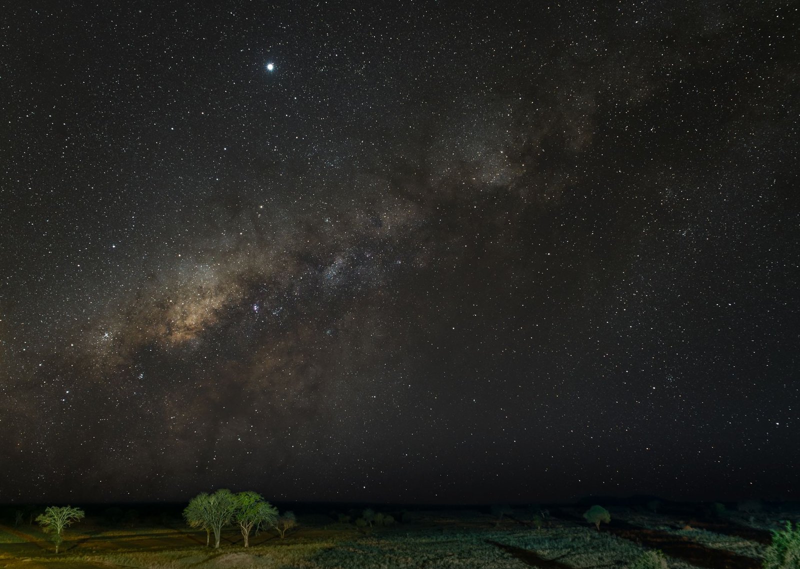 A stunning view of the Milky Way and stars shining over the serene landscape of Tsavo, Kenya.
