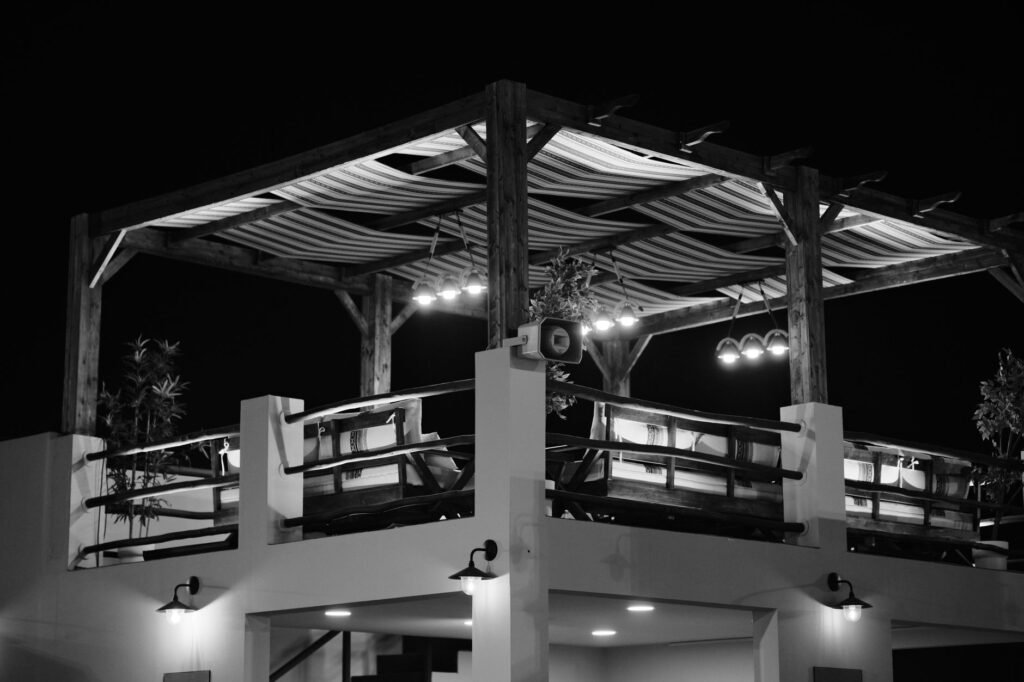Elegant black and white photo of a stylish rooftop dining area in Qatar at night.
