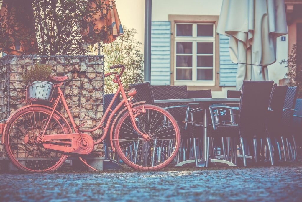 bicycle, pink bike, old bike, decoration, street cafe, outdoor catering, city, paved road, exterior view, facade, in the free