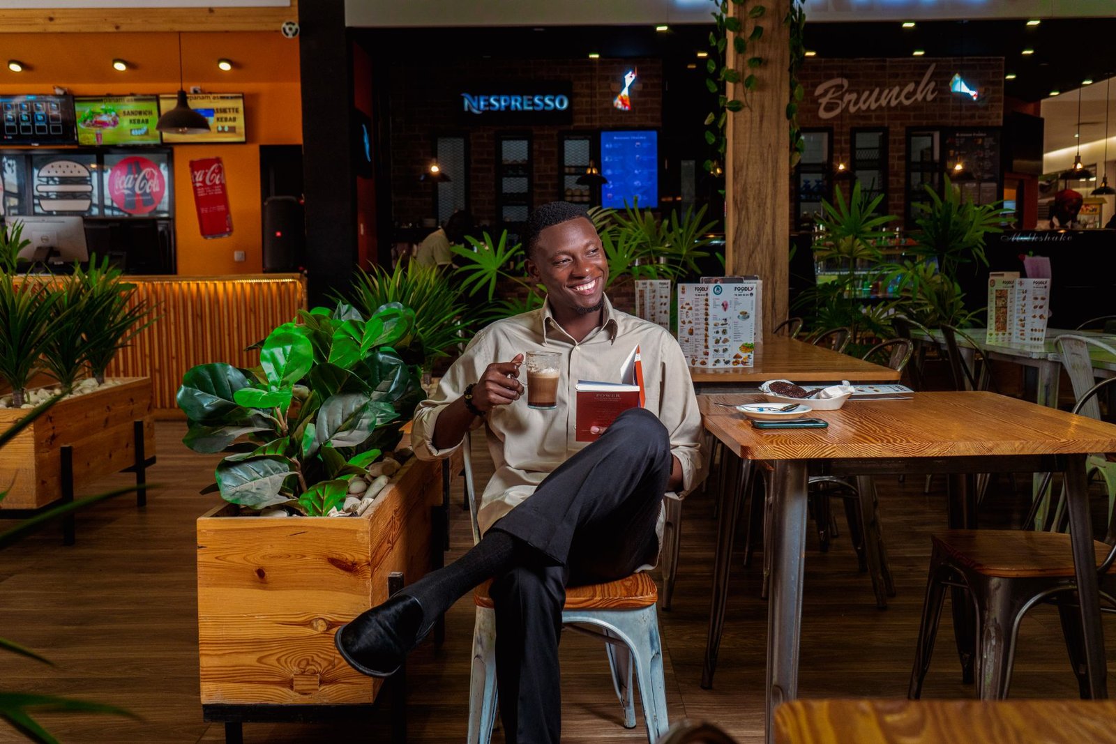 Man enjoying coffee and a book in a cozy café setting.