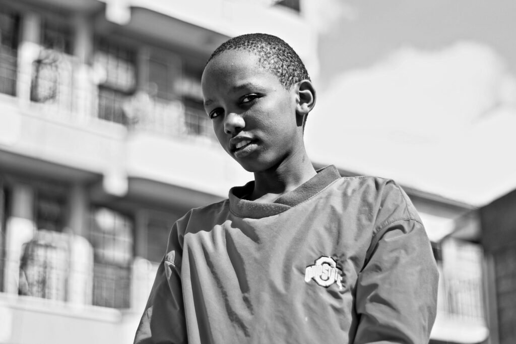Black and white portrait of a child outdoors in Nairobi.