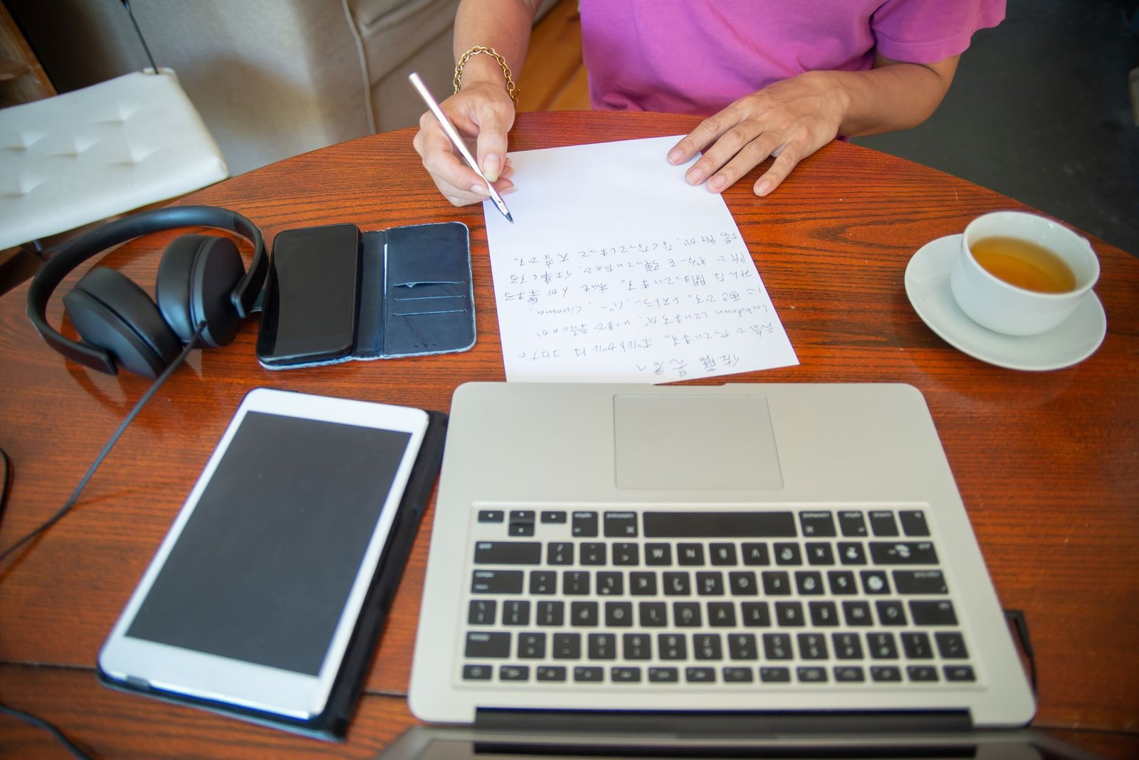 Smartphone, notebook and cup of tea on a wooden table in warm afternoon light