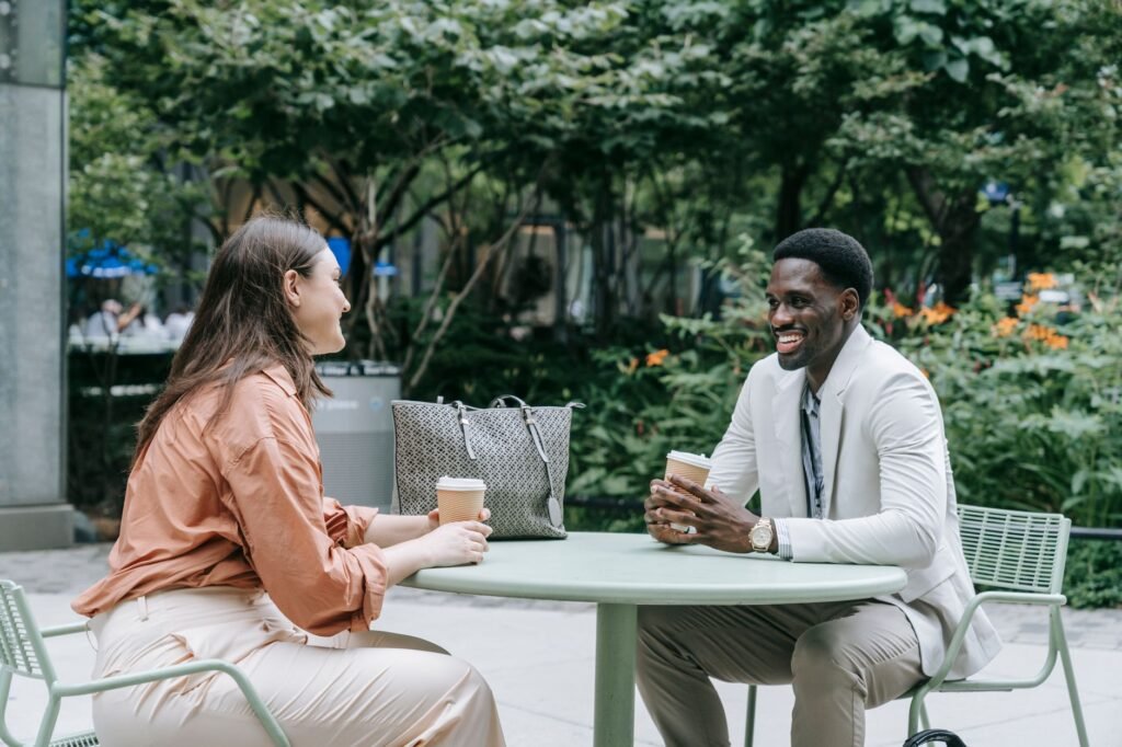 Two people meeting politely at an outdoor café table