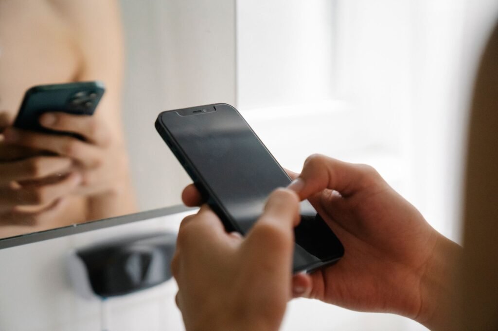 Person browsing listings on a smartphone at a table in daylight