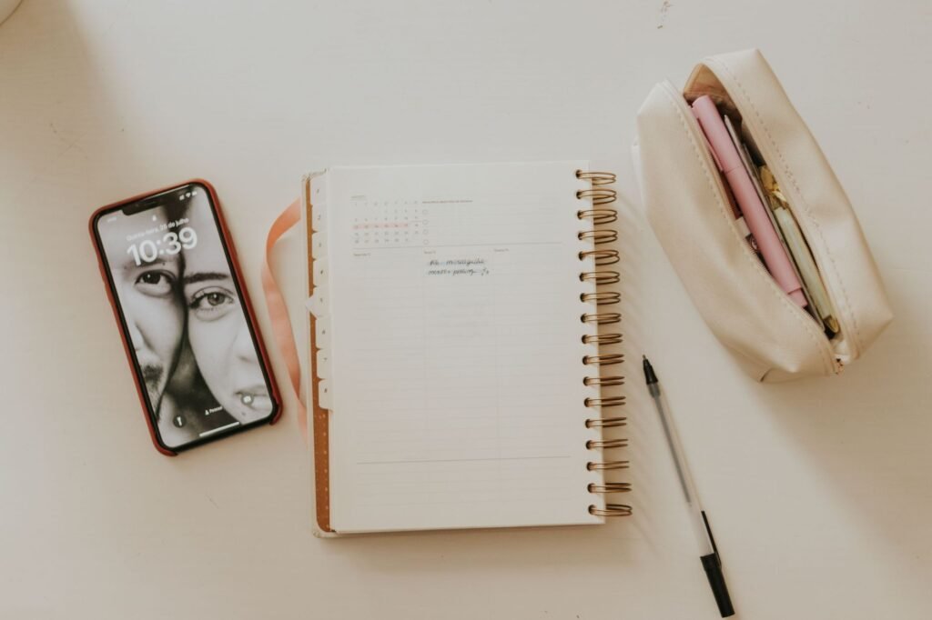 Smartphone and notebook on a table while planning a first enquiry