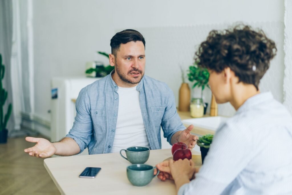 Two adults in a calm conversation at a small café table