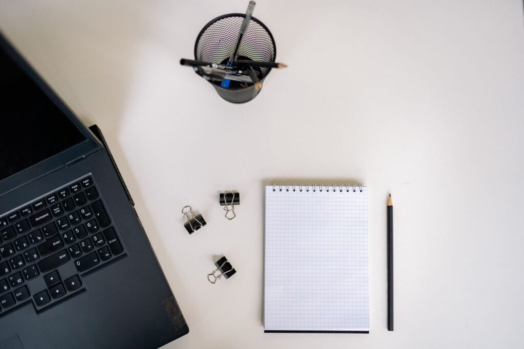Notepad, pen and laptop laid out for planning
