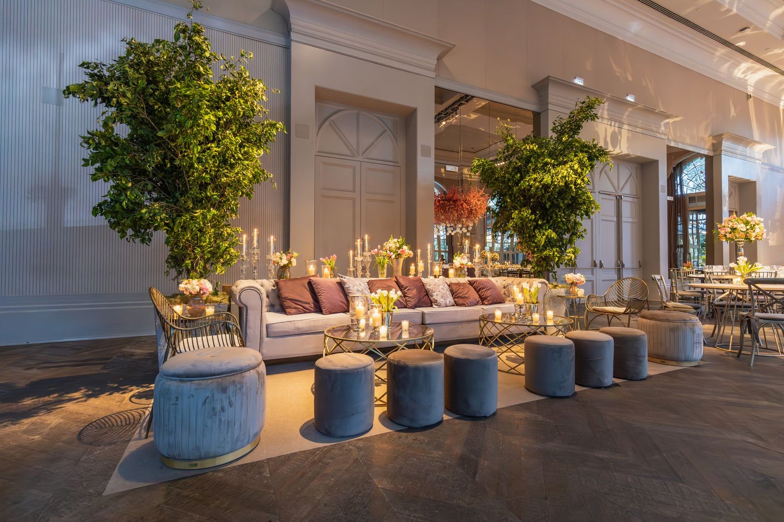 Elegant indoor lounge featuring plush seating, greenery, and candlelit ambiance.