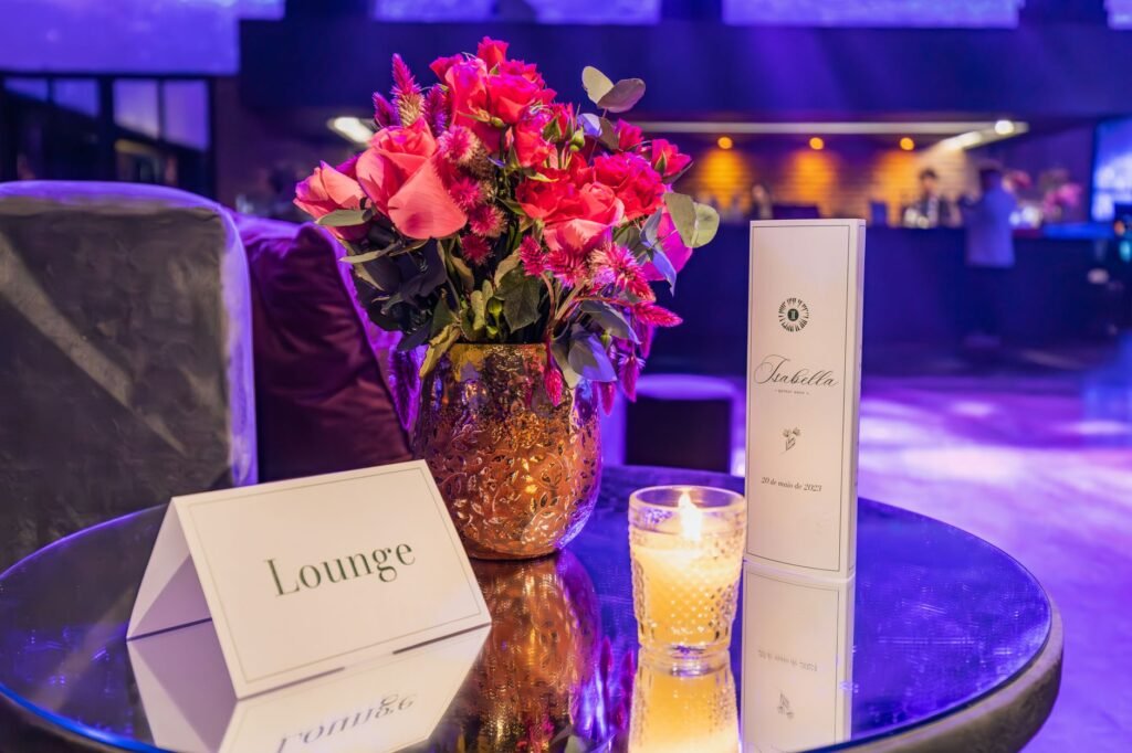 Cozy lounge table with vibrant floral centerpiece, candlelight, and menu cards for an intimate ambiance.