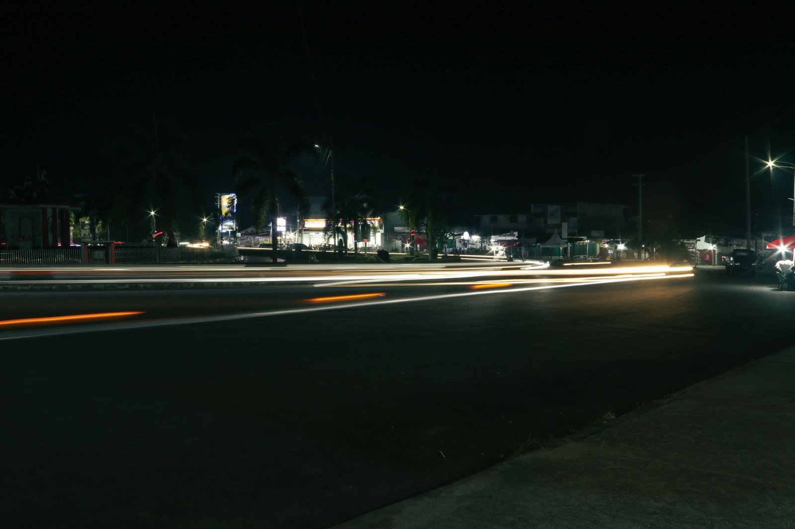 Urban night scene capturing car light trails on a busy street.