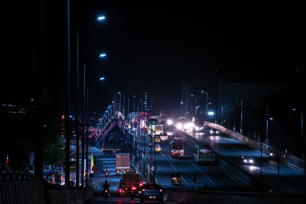 Dramatic night view of a busy highway bridge with moving traffic in India.