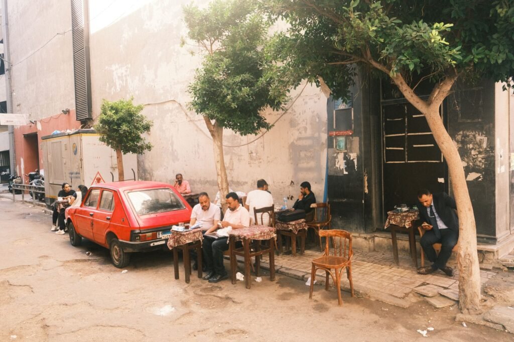 People enjoying coffee at a street café in Alexandria, Egypt.