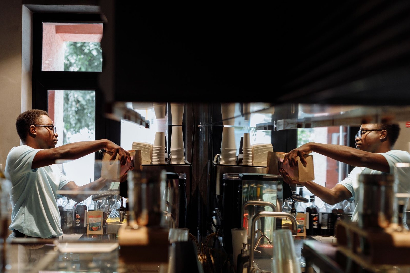 Barista working with an espresso machine in a stylish cafe environment.