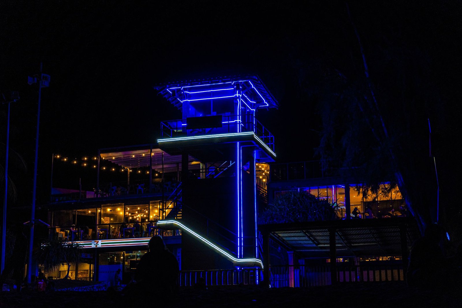 Colorful blue neon lights decorating a tower restaurant at night, showcasing lively nightlife.