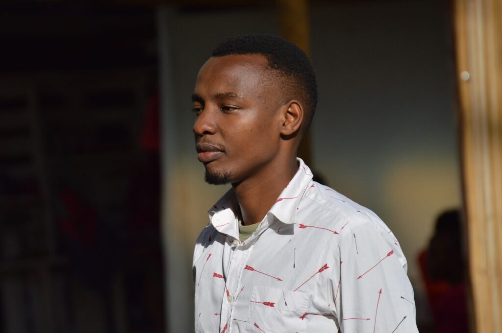 Close-up side view of an African adult male wearing a white shirt outdoors in Kenya.