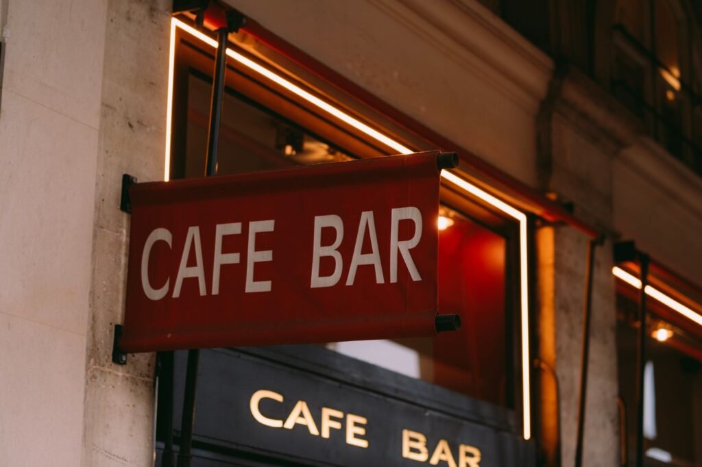 Stylish cafe bar sign illuminated with neon lights in urban setting. Perfect for restaurant and nightlife themes.