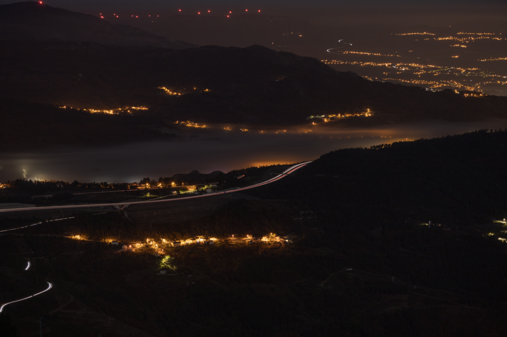 Dramatic aerial nighttime landscape with lights and hills in Vila Real District, Portugal.