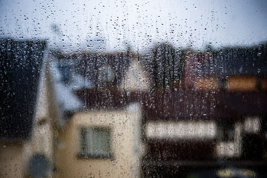 Blurred view of a rainy day in Bournemouth, capturing raindrops on a window.