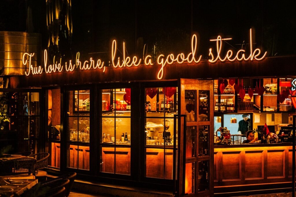 Warm, inviting restaurant facade with neon sign amid evening ambiance in Ho Chi Minh City.